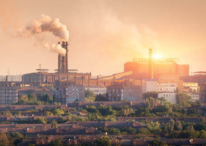 A sprawling steel mill at sunset, silhouetted against the sky.